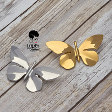 Load image into Gallery viewer, Gold and silver Ascend Brooches displayed side by side, featuring elegant butterfly designs in polished stainless steel with 18K PVD plating—symbolizing growth and resilience.