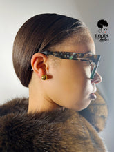 Load image into Gallery viewer, Person wearing glasses with a fur collar and gold earring, branded 'Loops & Lashes'.