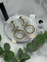 Load image into Gallery viewer, Elevate your style with 'Gilded Grace' Gold Earrings, boasting a minimalist geometric design with textured metal. These high-quality stainless steel dangle earrings are lightweight and graceful, featuring three vertically stacked circular/oval shapes for an added touch of elegance. Find your perfect accessory today and embrace the subtle sophistication of Gilded Grace.