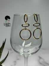Load image into Gallery viewer, Elevate your style with 'Gilded Grace' Gold Earrings, boasting a minimalist geometric design with textured metal. These high-quality stainless steel dangle earrings are lightweight and graceful, featuring three vertically stacked circular/oval shapes for an added touch of elegance. Find your perfect accessory today and embrace the subtle sophistication of Gilded Grace.