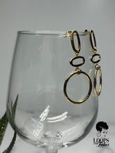 Load image into Gallery viewer, Elevate your style with 'Gilded Grace' Gold Earrings, boasting a minimalist geometric design with textured metal. These high-quality stainless steel dangle earrings are lightweight and graceful, featuring three vertically stacked circular/oval shapes for an added touch of elegance. Find your perfect accessory today and embrace the subtle sophistication of Gilded Grace.