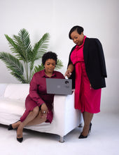 Load image into Gallery viewer, Two professional women in a corporate office setting reviewing a laptop, both styled in elegant business dresses and wearing Loops and Lashes® Zen Stud earrings, showcasing minimalist geometric gold stud design for modern workplace fashion.