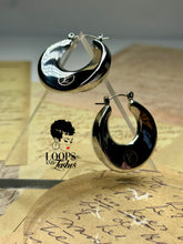 Load image into Gallery viewer, A pair of silver Dynasty Hoops with a sleek, minimalist hollow design, crafted from stainless steel with luxurious PVD gold plating. These water-resistant hoops, engraved with a signature submark logo, symbolize timeless elegance and strength. Perfect for everyday wear or statement styling, they honor the legacy of bold, stylish women across generations.