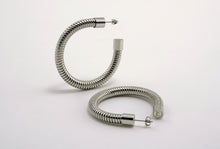 Load image into Gallery viewer, A pair of Heritage Hoops in sleek silver, crafted from high-quality stainless steel with a durable PVD plating. These two-inch open hoop earrings feature a unique textured design and an exclusive engraved submark logo, symbolizing timeless elegance and empowerment. Waterproof and tarnish-resistant, they blend modern sophistication with lasting quality.