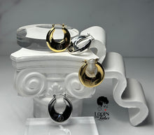 Load image into Gallery viewer, Gold and Silver Dynasty Hoops with a sleek, minimalist hollow design, crafted from stainless steel with luxurious PVD gold plating. These water-resistant hoops, engraved with a signature submark logo, symbolize timeless elegance and strength. Perfect for everyday wear or statement styling, they honor the legacy of bold, stylish women across generations.