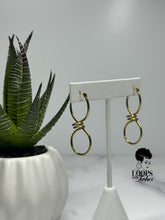 Load image into Gallery viewer, Discover the allure of these captivating infinity sign-shaped hoops featuring intricate winding at the center. Elevate your style with these unique statement pieces that embody timeless elegance. Suitable for all occasions, these earrings are a symbol of everlasting grace.