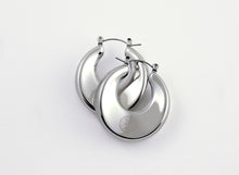 Load image into Gallery viewer, A pair of silver Dynasty Hoops with a sleek, minimalist hollow design, crafted from stainless steel with luxurious PVD gold plating. These water-resistant hoops, engraved with a signature submark logo, symbolize timeless elegance and strength. Perfect for everyday wear or statement styling, they honor the legacy of bold, stylish women across generations.