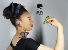 Load image into Gallery viewer, Side profile of girl wearing silver Fearless Wings butterfly earrings and a black shirt, with a delicate butterfly resting on her shoulder and hand. Bold jewelry styling with nature-inspired elegance.