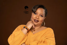 Load image into Gallery viewer, The picture is of a woman wearing a pair of bamboo earrings made from lightweight iron alloy material. They are in a circular hoop shape and have a leopard print design on them. The earrings have a gold-toned metal stem that goes through the earlobe.