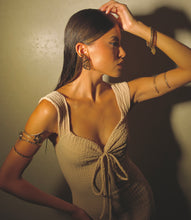 Load image into Gallery viewer, Woman wearing a beige dress with intricate detailing, standing against a neutral background wearing gold butterfly Stud Earrings.
