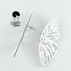 Silver Fearless Wings earrings with intricate wing-inspired design, symbolizing empowerment and transformation, lightweight statement jewelry for bold, confident women. One earring shows the side view.