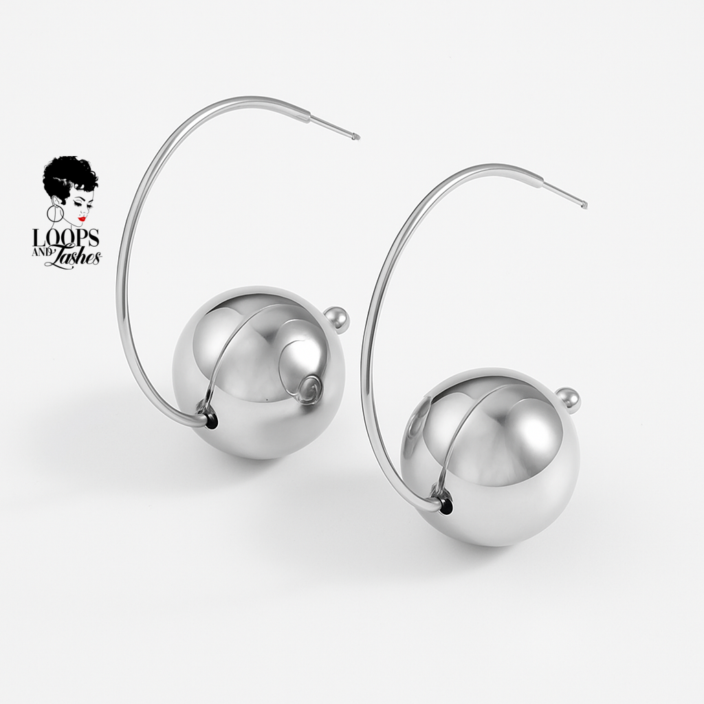 Silver hoop earrings with spherical ball on a white background, featuring the brand 'Loops of Lashes'.